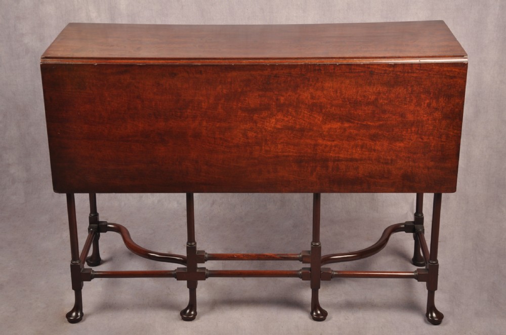 An 18th-century dark mahogany spider leg table featuring slender turned legs, curved stretchers, pad feet, and a drop-leaf top. View II