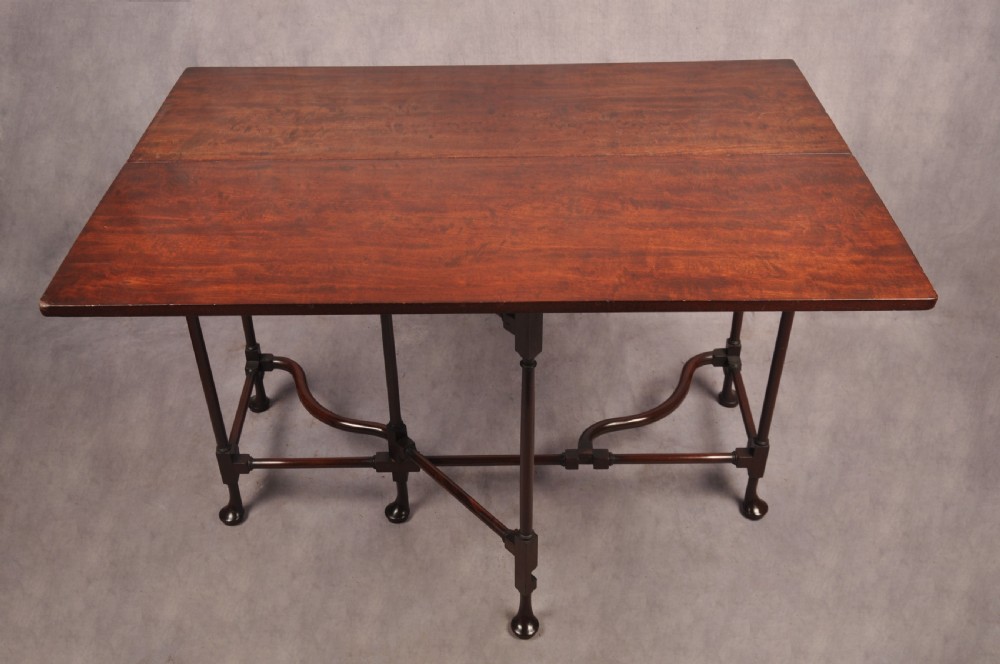 An 18th-century dark mahogany spider leg table featuring slender turned legs, curved stretchers, pad feet, and a drop-leaf top. View IV