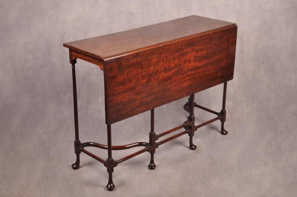 An 18th-century dark mahogany spider leg table featuring slender turned legs, curved stretchers, pad feet, and a drop-leaf top. View V