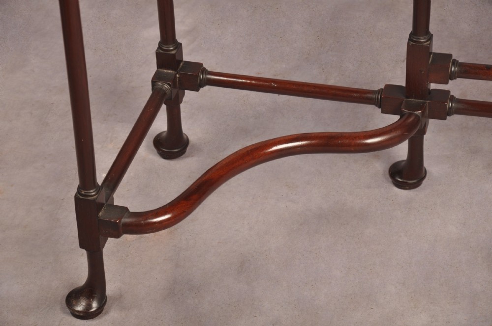 An 18th-century dark mahogany spider leg table featuring slender turned legs, curved stretchers, pad feet, and a drop-leaf top. View VII