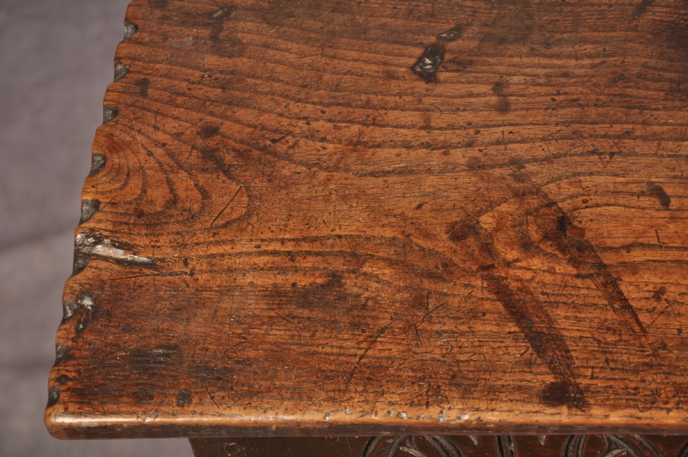 A dark oak 17th century coffer featuring carved lozenge motifs across three front panels beneath an arcaded frieze and iron lockplate. View X