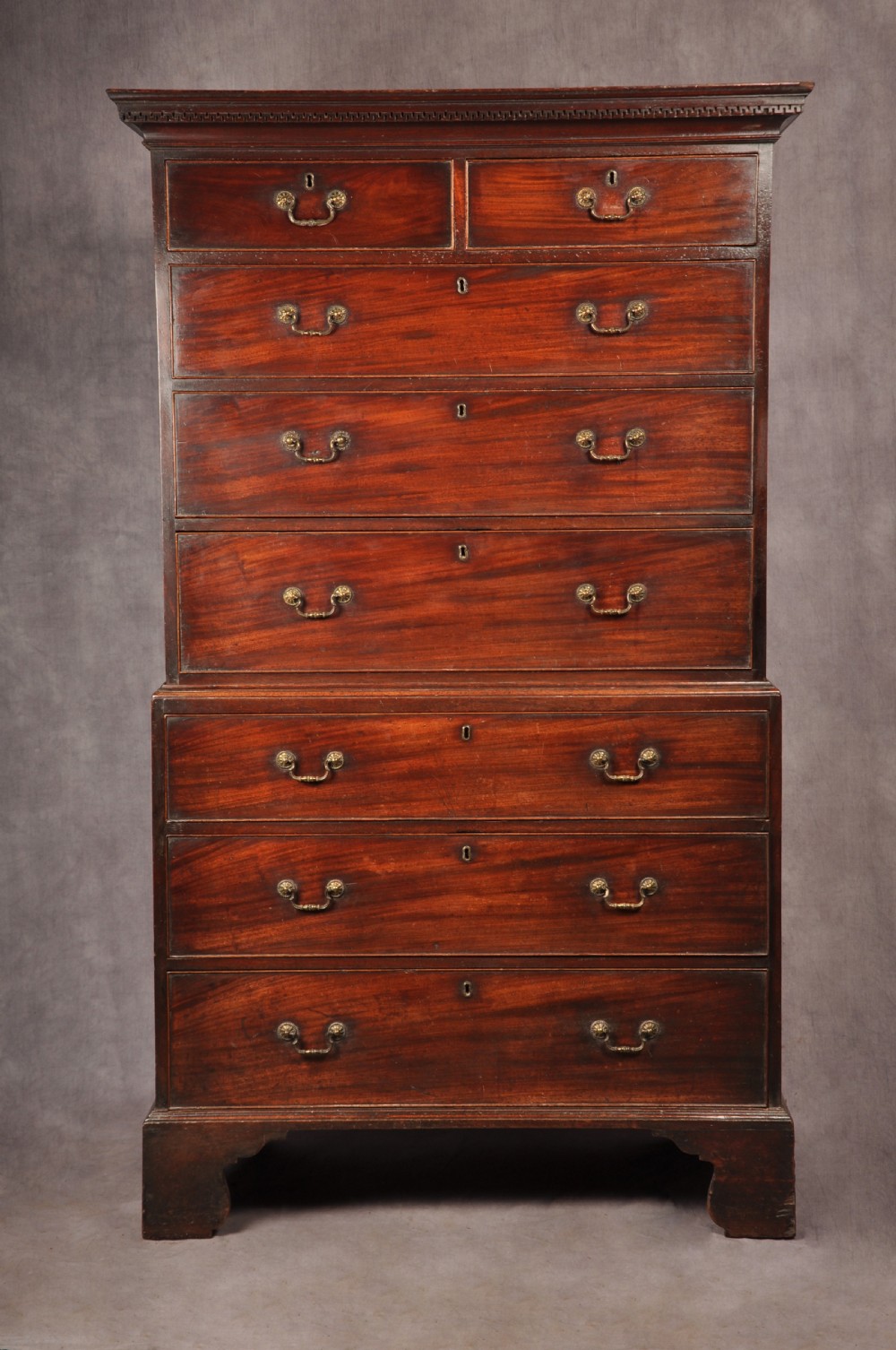 An 18th-century Georgian mahogany tallboy chest-on-chest featuring two short drawers over five long drawers with brass handles and bracket feet.