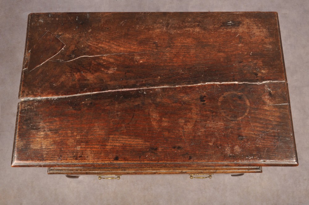 An early eighteenth-century oak coffer bach with star inlay details, a hinged top lid, a single lower drawer, and brass handles. View IV