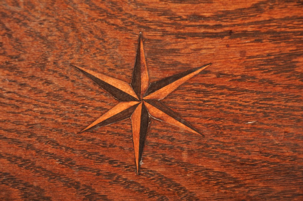 An early eighteenth-century oak coffer bach with star inlay details, a hinged top lid, a single lower drawer, and brass handles. View VI