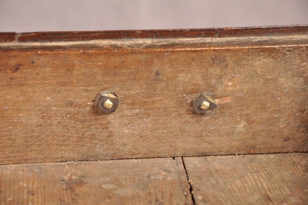 An early eighteenth-century oak coffer bach with star inlay details, a hinged top lid, a single lower drawer, and brass handles. View X