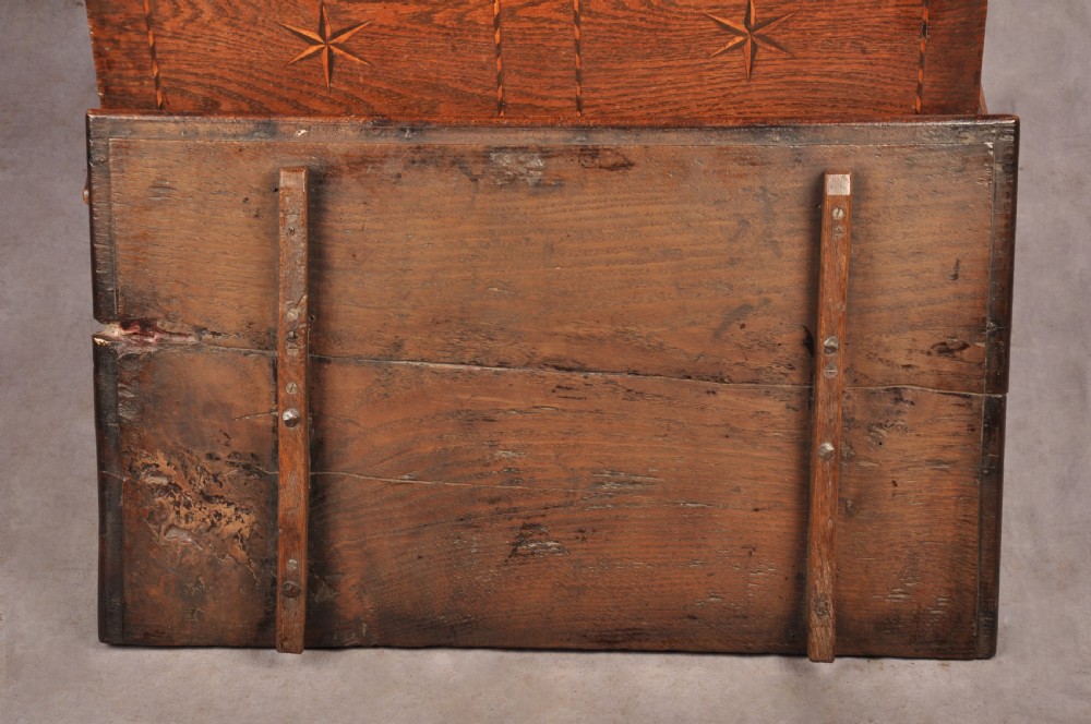 An early eighteenth-century oak coffer bach with star inlay details, a hinged top lid, a single lower drawer, and brass handles. View XI