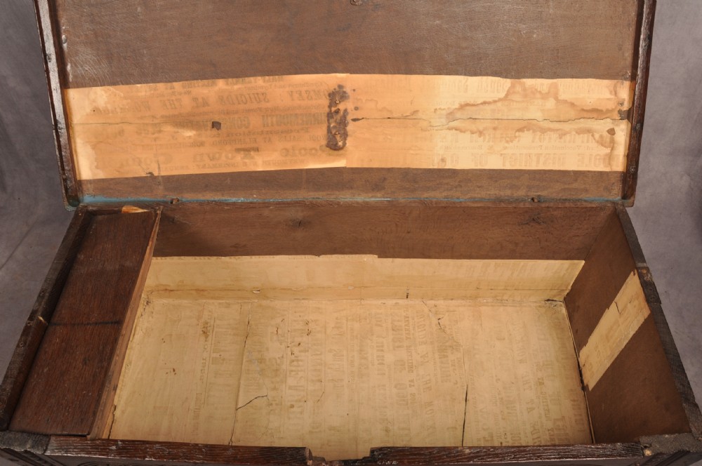 A small 17th-century dark oak coffer featuring carved lozenge and lunette patterns across the front with an iron escutcheon plate. View VIII