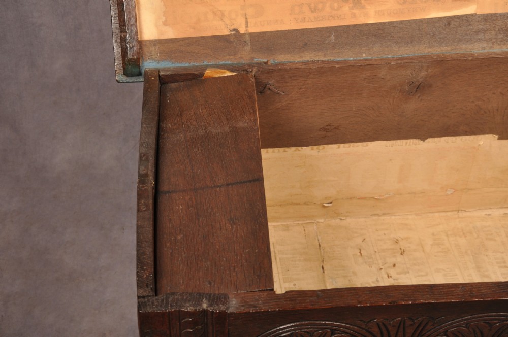 A small 17th-century dark oak coffer featuring carved lozenge and lunette patterns across the front with an iron escutcheon plate. View IX