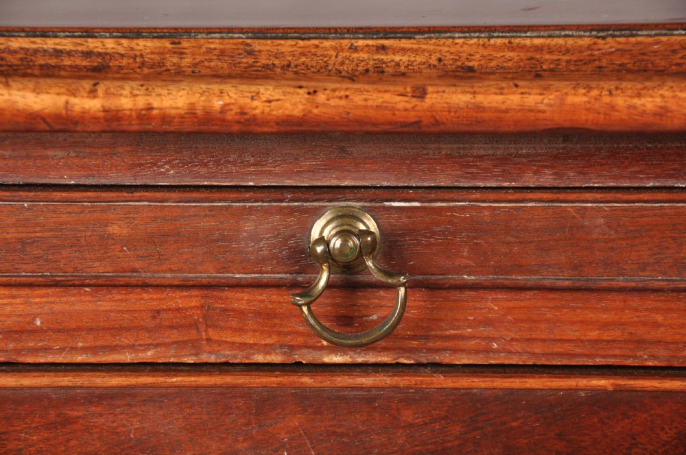 An 18th-century Georgian mahogany chest of drawers featuring four graduated drawers with brass swan-neck handles, keyholes, a pull-out brushing slide, and bracket feet. View III