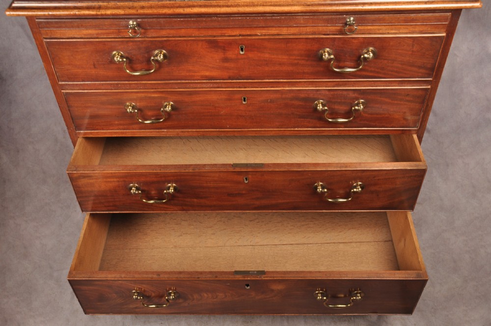 An 18th-century Georgian mahogany chest of drawers featuring four graduated drawers with brass swan-neck handles, keyholes, a pull-out brushing slide, and bracket feet. View VII
