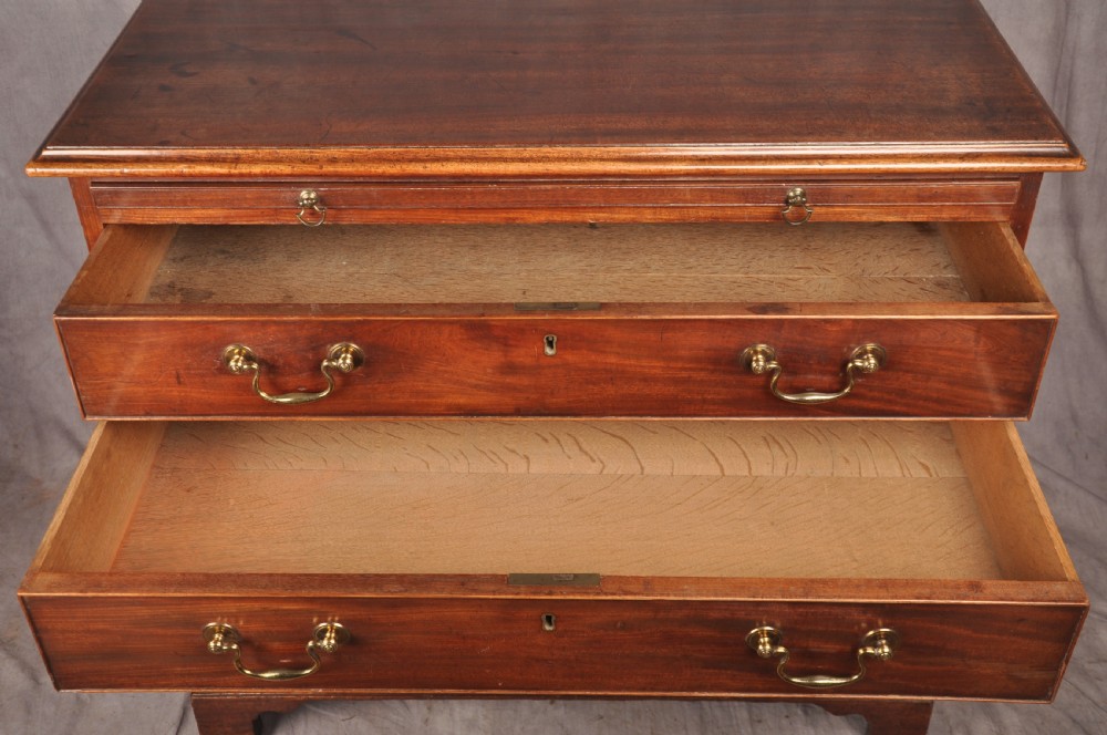 An 18th-century Georgian mahogany chest of drawers featuring four graduated drawers with brass swan-neck handles, keyholes, a pull-out brushing slide, and bracket feet. View VIII