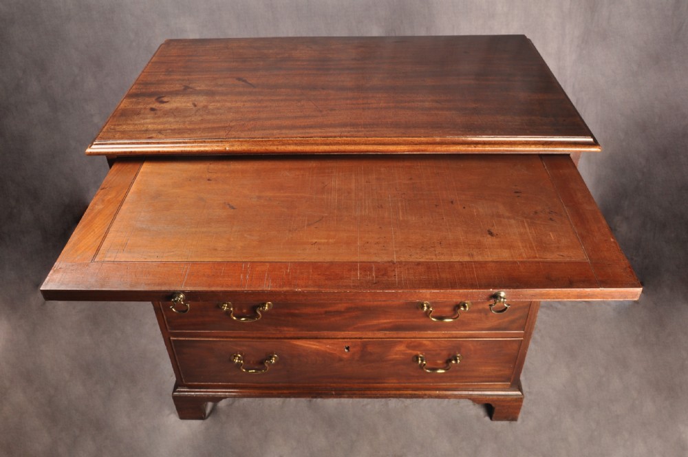 An 18th-century Georgian mahogany chest of drawers featuring four graduated drawers with brass swan-neck handles, keyholes, a pull-out brushing slide, and bracket feet. View X