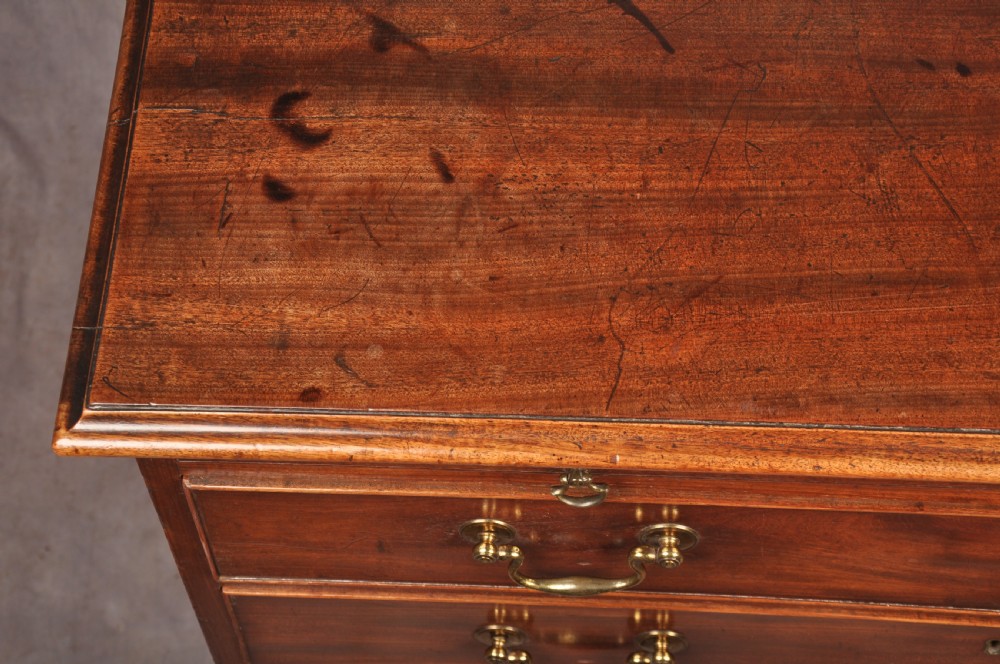An 18th-century Georgian mahogany chest of drawers featuring four graduated drawers with brass swan-neck handles, keyholes, a pull-out brushing slide, and bracket feet. View XII