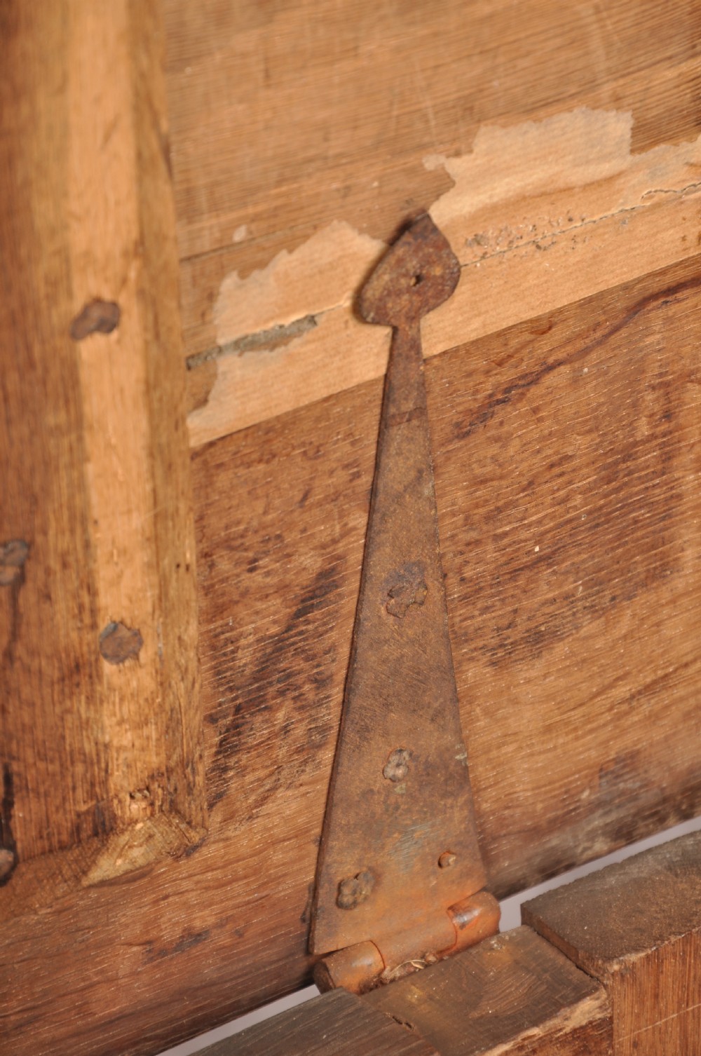An 18th-century carved oak mule chest featuring three relief-carved front panels, a carved dated top frieze reading 1712, and two lower geometric drawers. View XIII