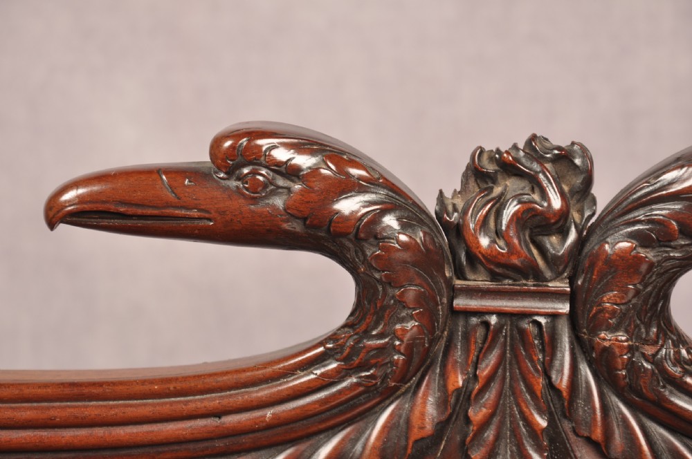 An antique Regency mahogany sideboard featuring flame mahogany panel doors, brass lion mask ring handles, spiral turned columns, hairy paw feet, and a central backboard mirror. View VII