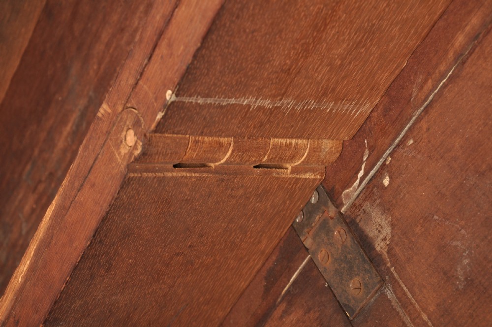 An 18th-century mahogany drop-leaf gateleg table with tapered legs, pad feet, and a scalloped apron on a plain background. View X
