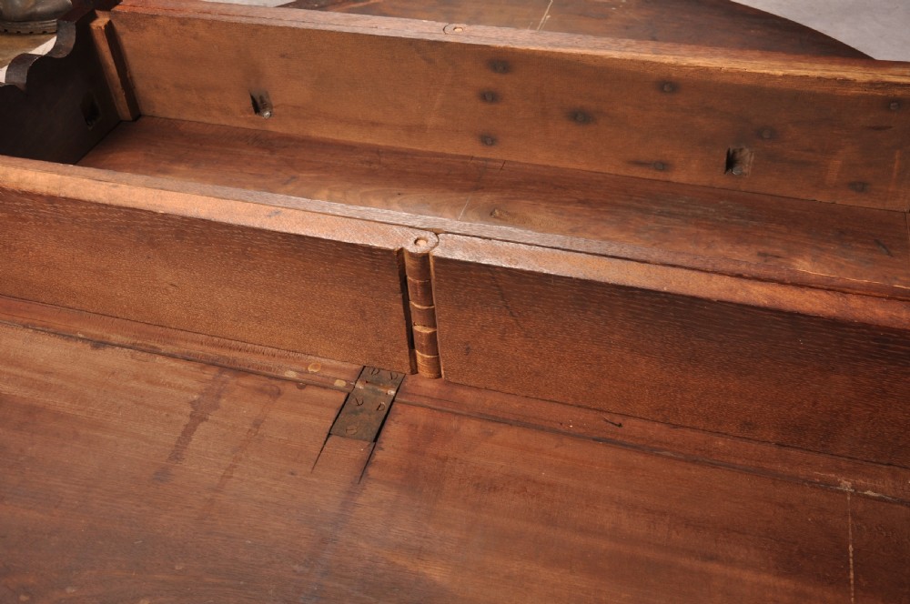 An 18th-century mahogany drop-leaf gateleg table with tapered legs, pad feet, and a scalloped apron on a plain background. View XIII