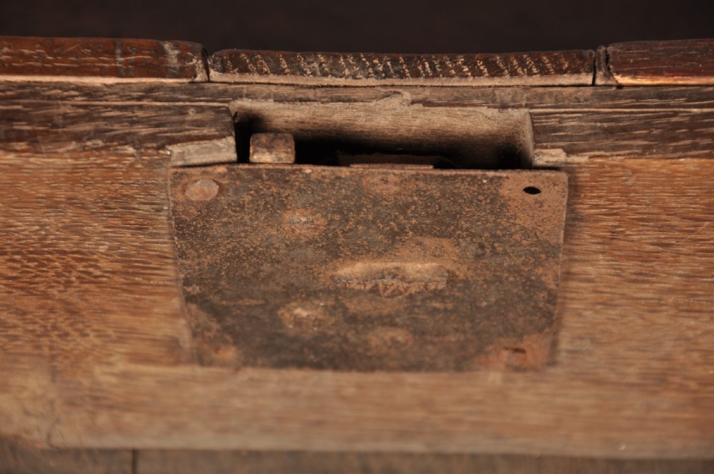 A 17th-century dark oak chest of drawers featuring geometric mouldings, split baluster details, brass drop handles, and a scalloped apron. View XII