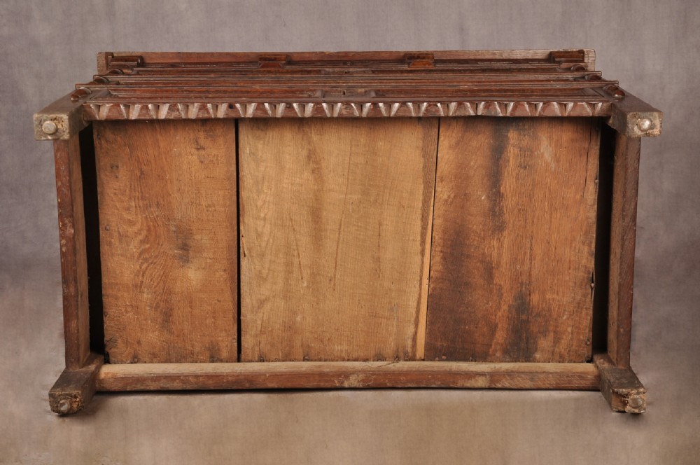 A 17th-century dark oak chest of drawers featuring geometric mouldings, split baluster details, brass drop handles, and a scalloped apron. View XXI
