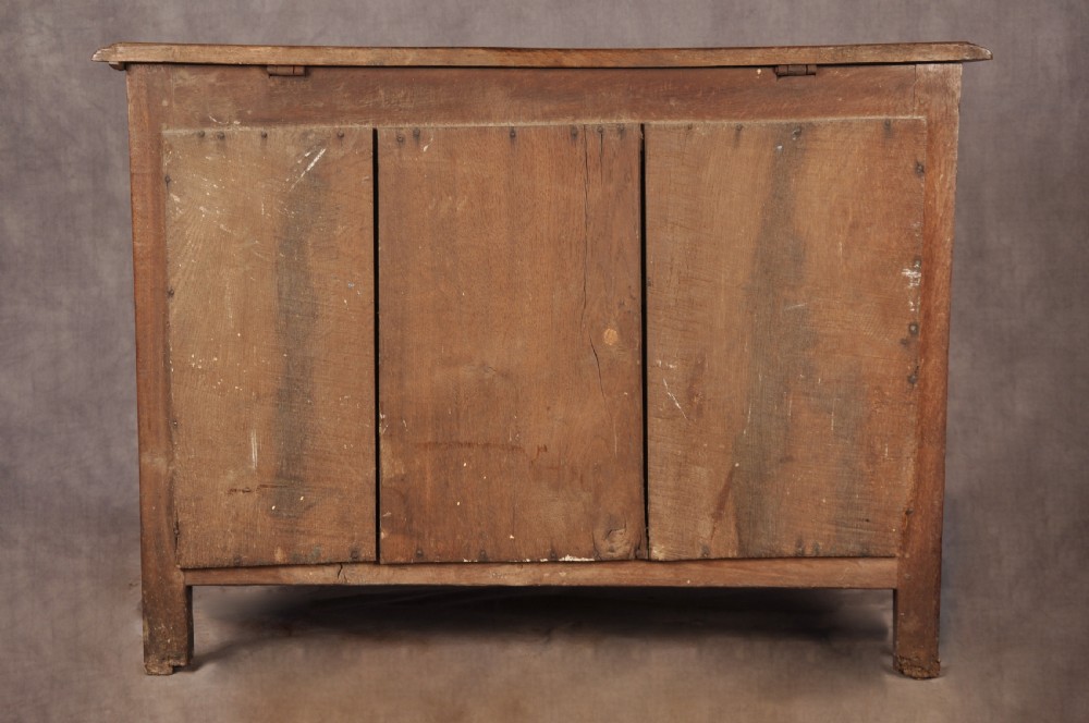 A 17th-century dark oak chest of drawers featuring geometric mouldings, split baluster details, brass drop handles, and a scalloped apron. View XXII
