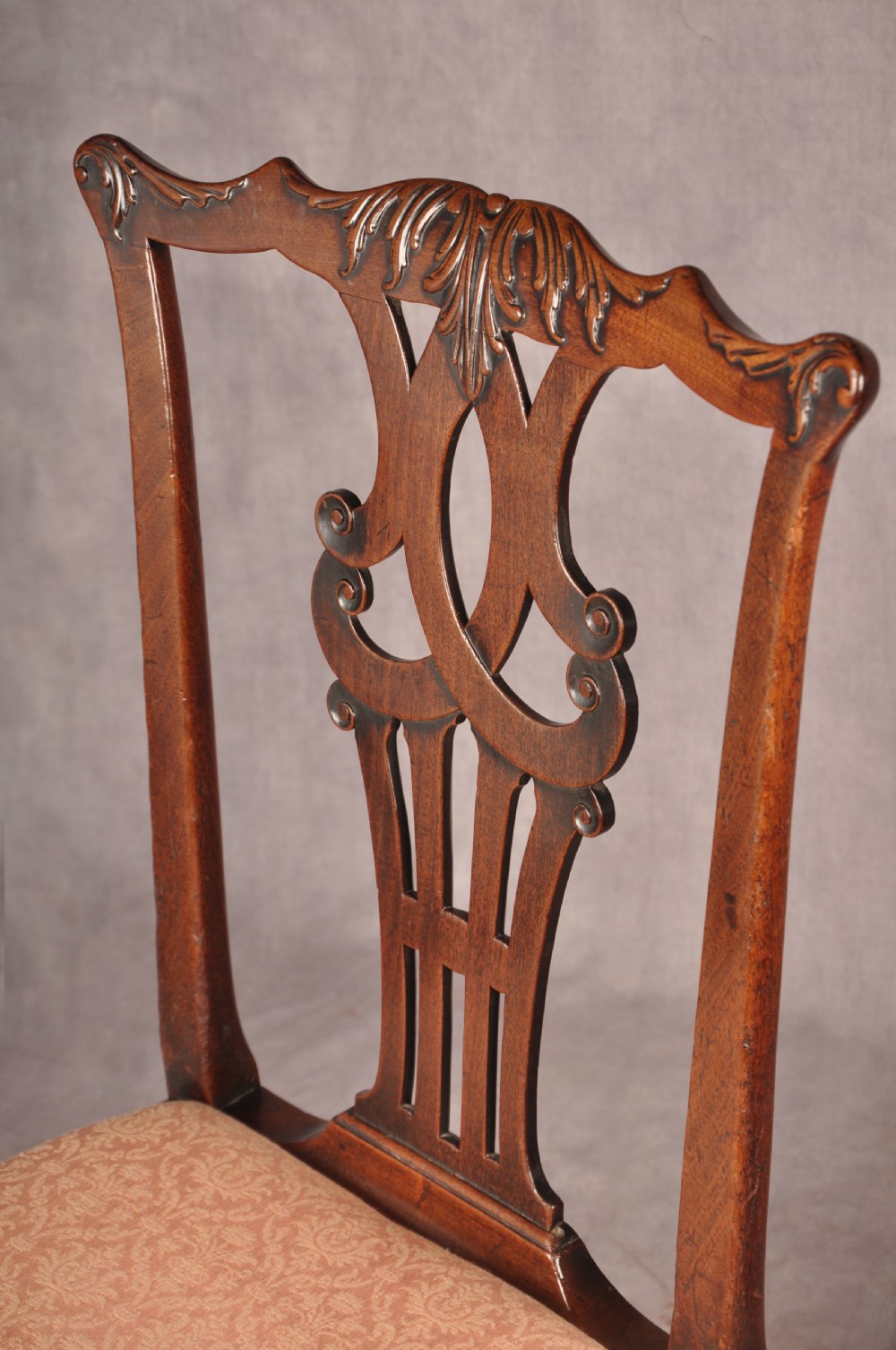 A pair of 18th-century mahogany Chippendale side chairs featuring carved pierced back splats and light patterned upholstered seat pads. View II