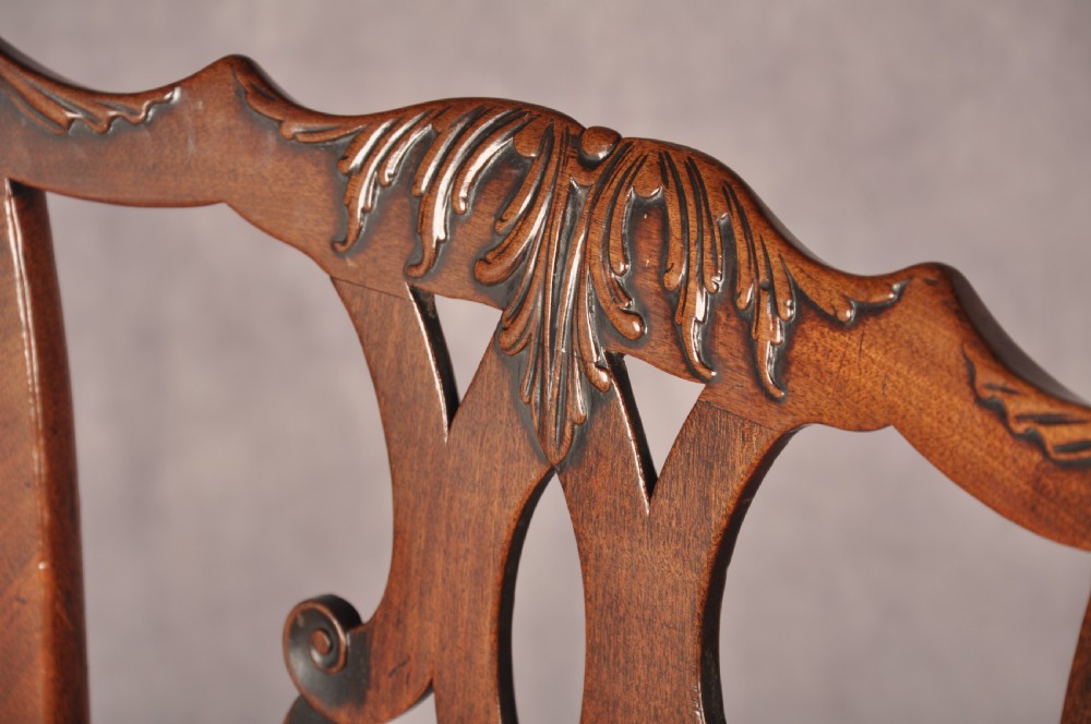 A pair of 18th-century mahogany Chippendale side chairs featuring carved pierced back splats and light patterned upholstered seat pads. View IV