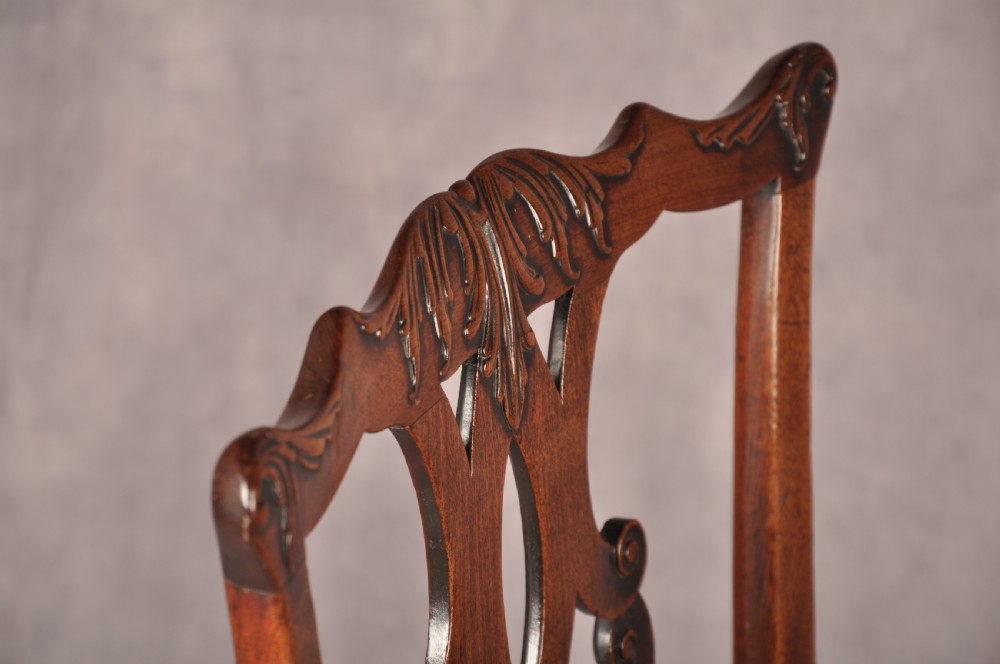A pair of 18th-century mahogany Chippendale side chairs featuring carved pierced back splats and light patterned upholstered seat pads. View VI