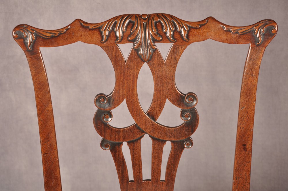 A pair of 18th-century mahogany Chippendale side chairs featuring carved pierced back splats and light patterned upholstered seat pads. View VII