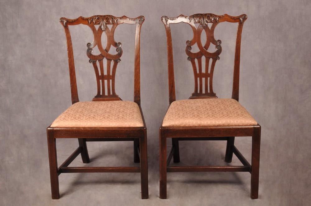 A pair of 18th-century mahogany Chippendale side chairs featuring carved pierced back splats and light patterned upholstered seat pads. View IX
