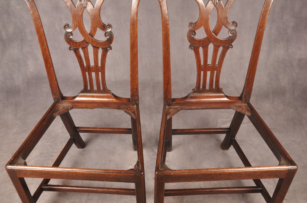 A pair of 18th-century mahogany Chippendale side chairs featuring carved pierced back splats and light patterned upholstered seat pads. View XI