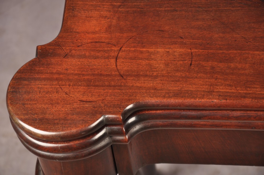 An 18th-century dark mahogany triple-top card table with shaped cabriole legs ending in pad feet. View V