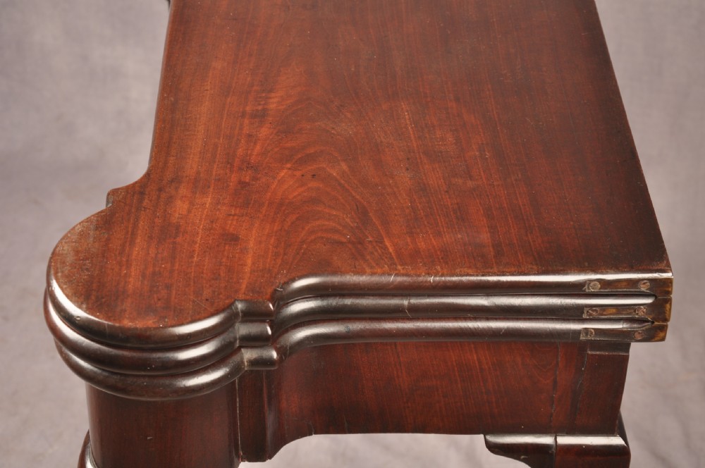 An 18th-century dark mahogany triple-top card table with shaped cabriole legs ending in pad feet. View VI