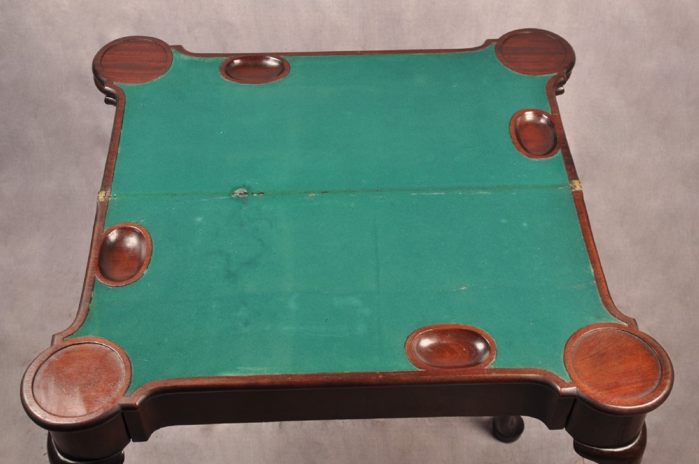 An 18th-century dark mahogany triple-top card table with shaped cabriole legs ending in pad feet. View VIII