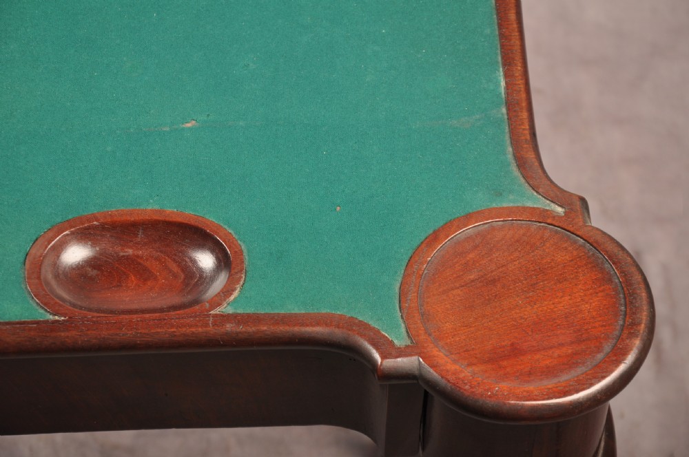 An 18th-century dark mahogany triple-top card table with shaped cabriole legs ending in pad feet. View IX
