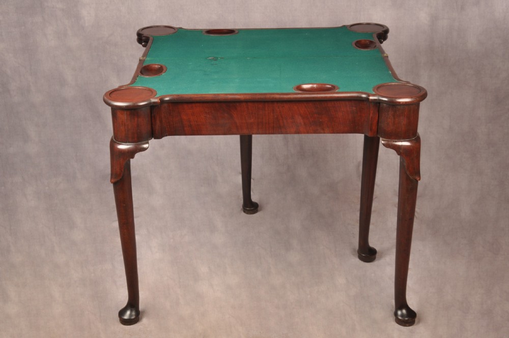 An 18th-century dark mahogany triple-top card table with shaped cabriole legs ending in pad feet. View XI