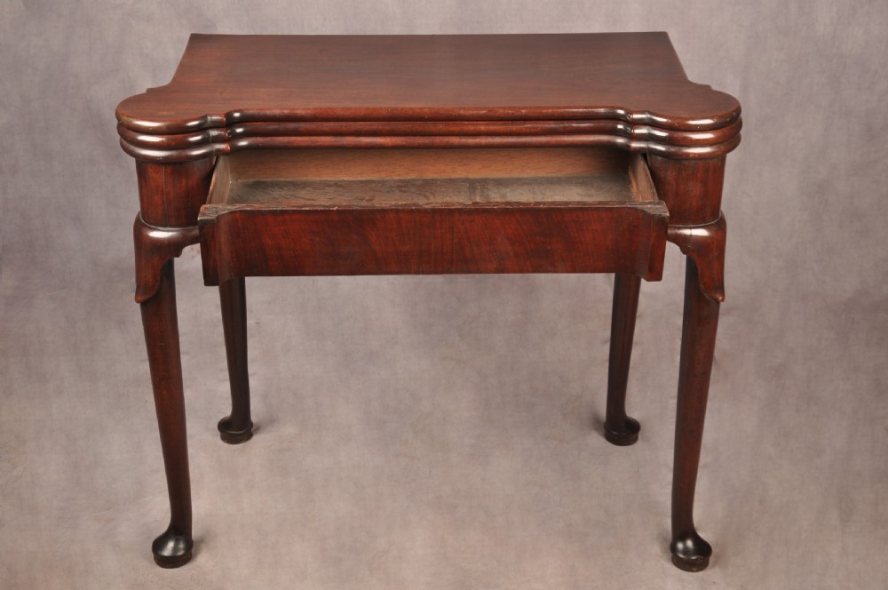 An 18th-century dark mahogany triple-top card table with shaped cabriole legs ending in pad feet. View XIII