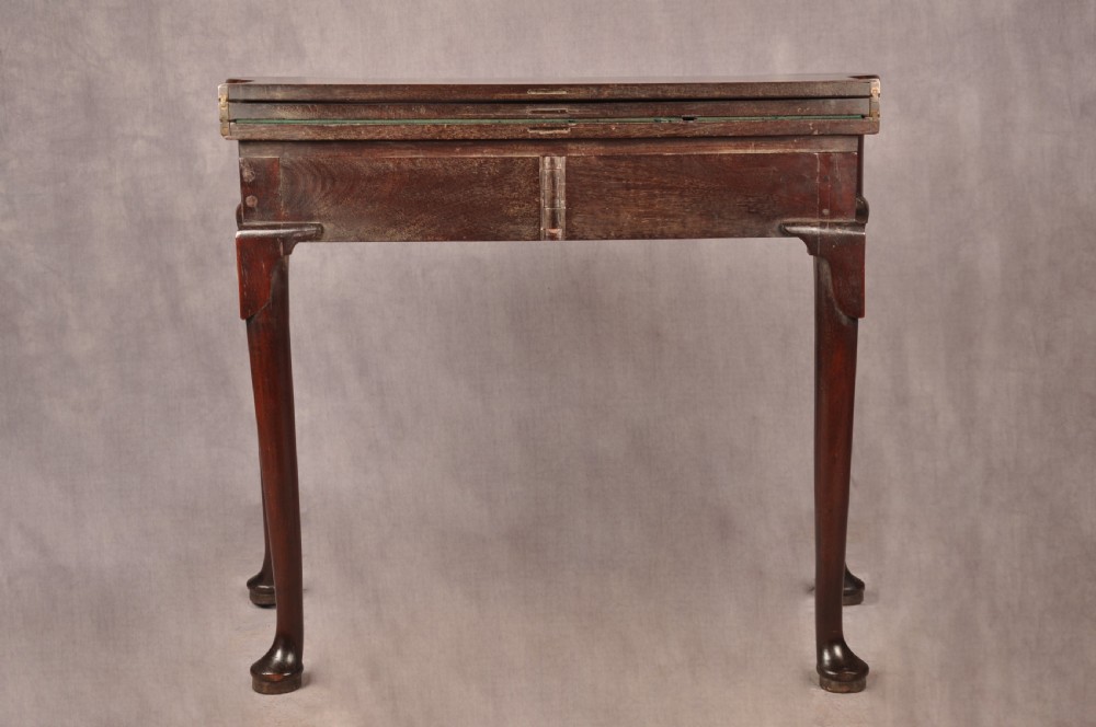 An 18th-century dark mahogany triple-top card table with shaped cabriole legs ending in pad feet. View XV