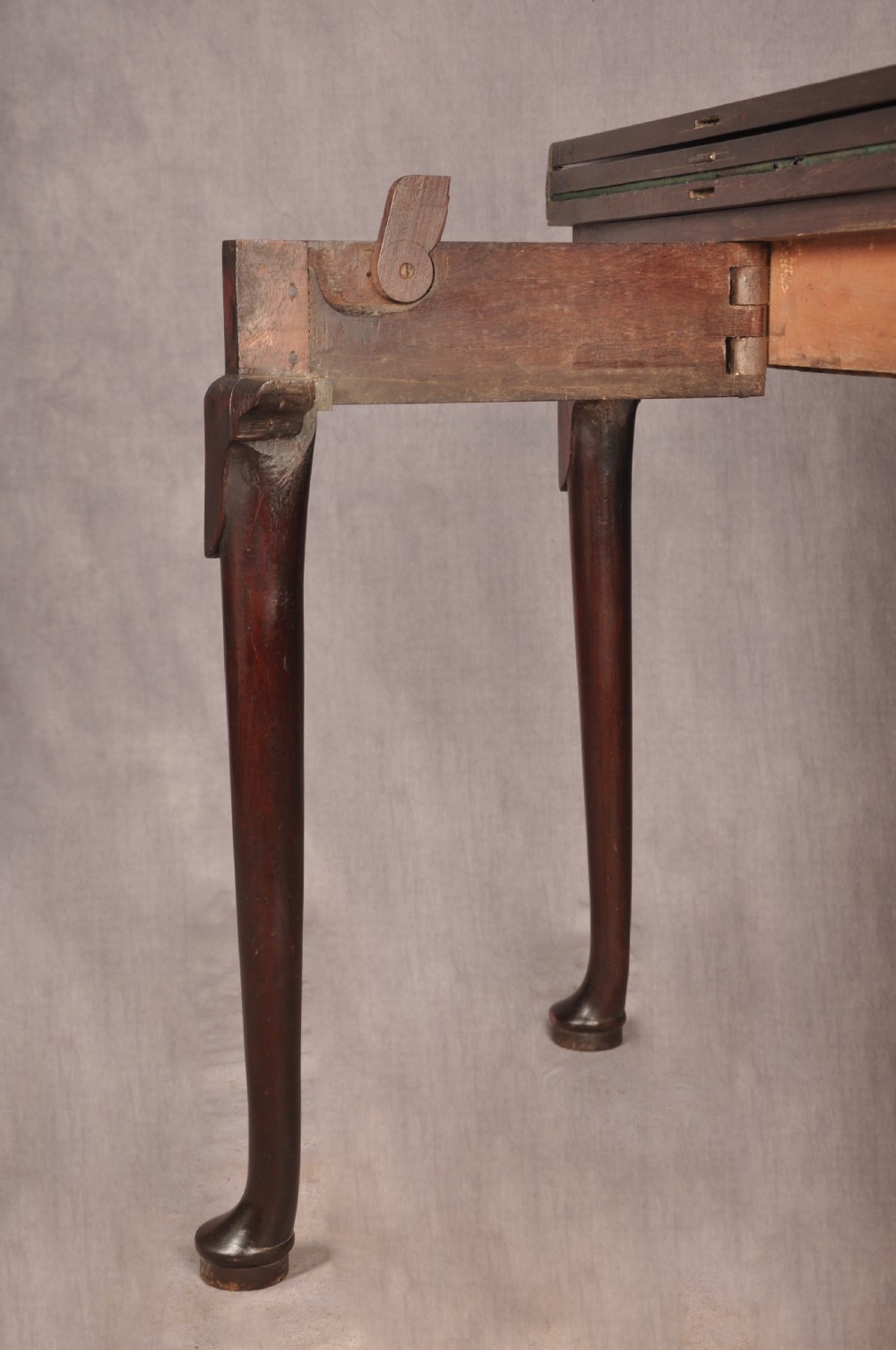 An 18th-century dark mahogany triple-top card table with shaped cabriole legs ending in pad feet. View XVI