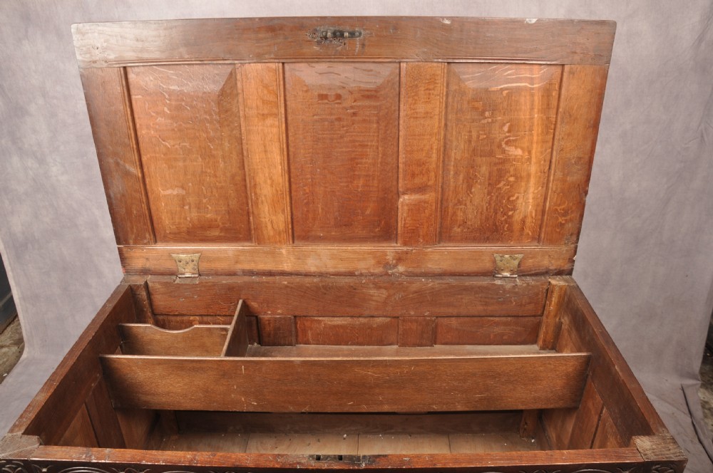 A 17th-century dark oak coffer featuring three carved arcaded panels with central diamond lozenge designs and carved lunette friezes. View VIII