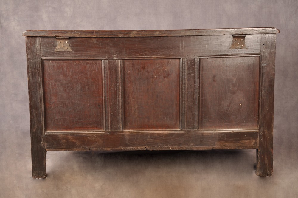 A 17th-century dark oak coffer featuring three carved arcaded panels with central diamond lozenge designs and carved lunette friezes. View XII
