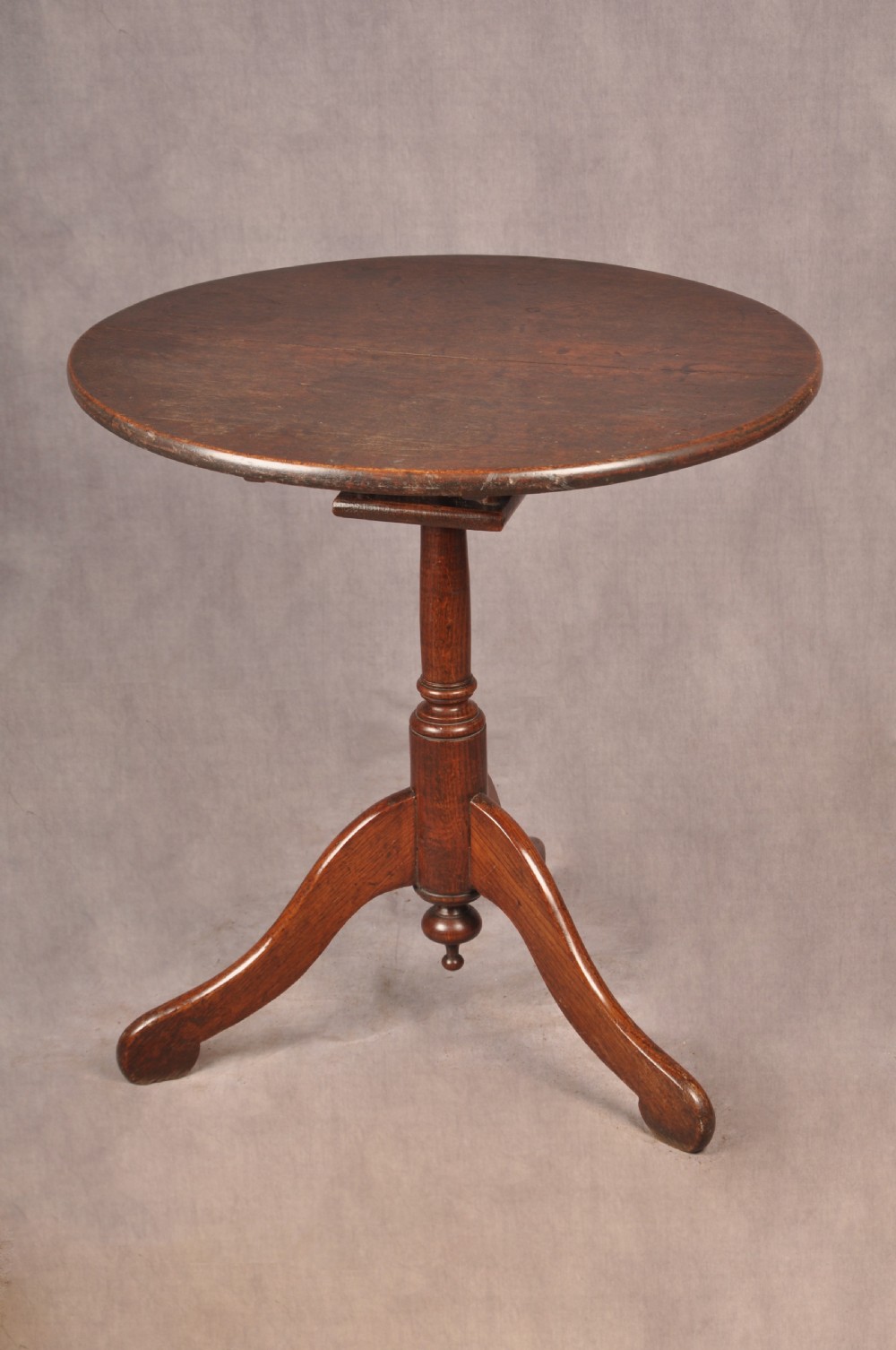 An 18th-century dark oak tripod table featuring a circular top, turned spindle birdcage stem, and three splayed cabriole legs. View II