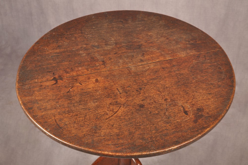 An 18th-century dark oak tripod table featuring a circular top, turned spindle birdcage stem, and three splayed cabriole legs. View III