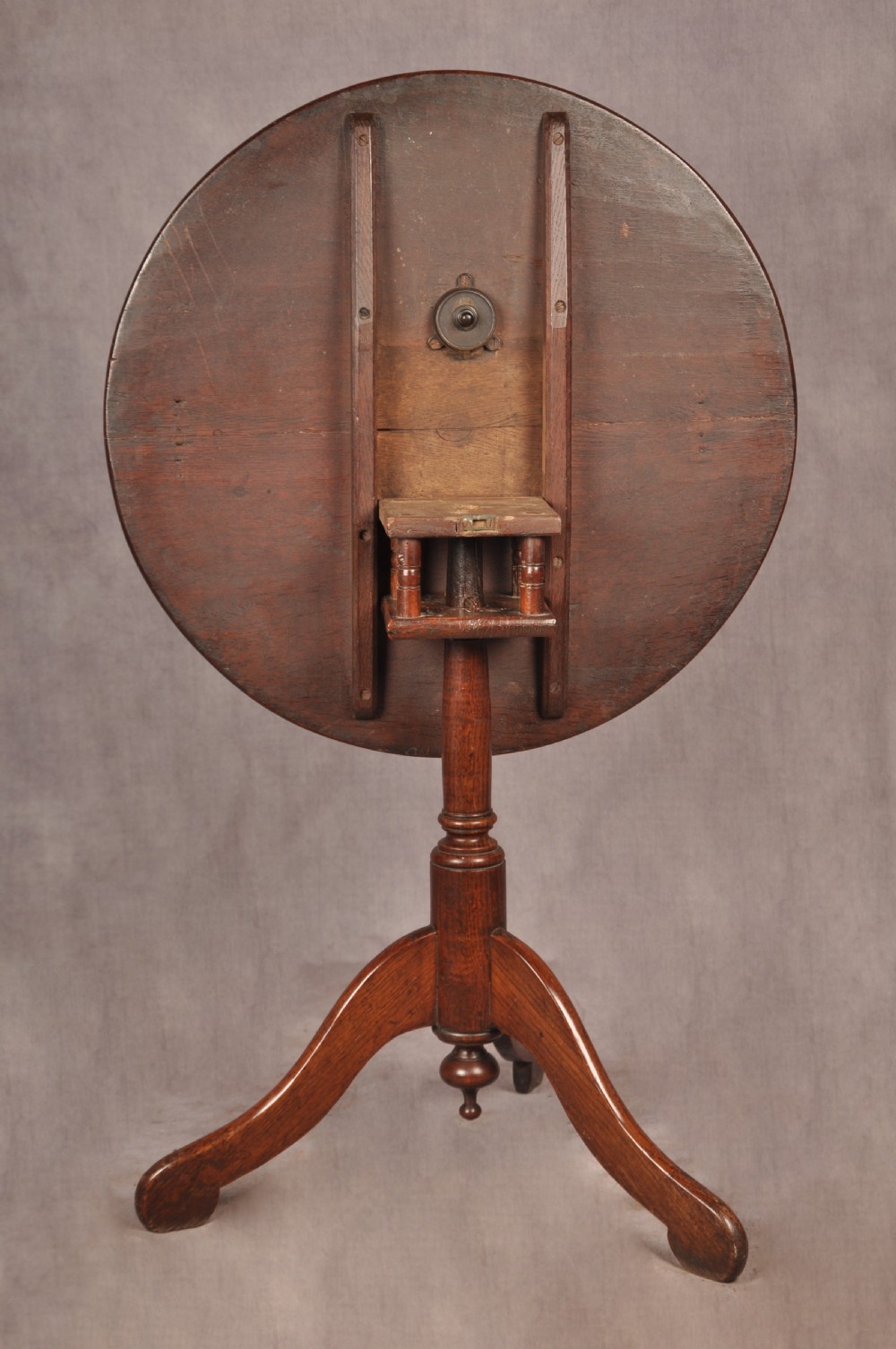 An 18th-century dark oak tripod table featuring a circular top, turned spindle birdcage stem, and three splayed cabriole legs. View VI