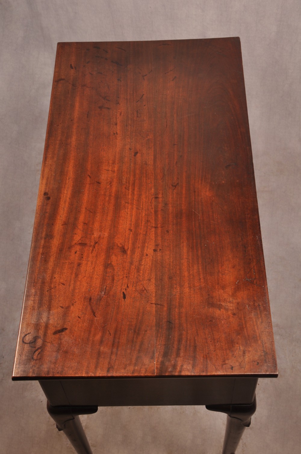 An early 18th-century mahogany lowboy with three drawers, brass handles, a shaped apron, and four cabriole legs with pad feet. View II