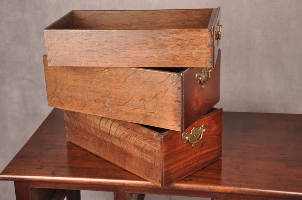 An early 18th-century mahogany lowboy with three drawers, brass handles, a shaped apron, and four cabriole legs with pad feet. View IV