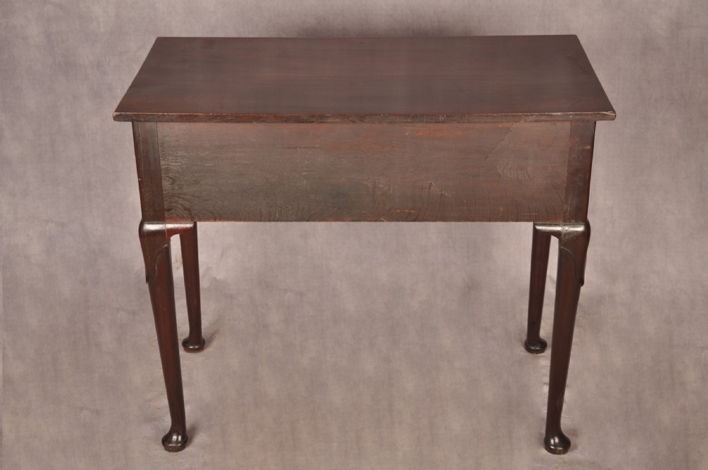 An early 18th-century mahogany lowboy with three drawers, brass handles, a shaped apron, and four cabriole legs with pad feet. View XIII