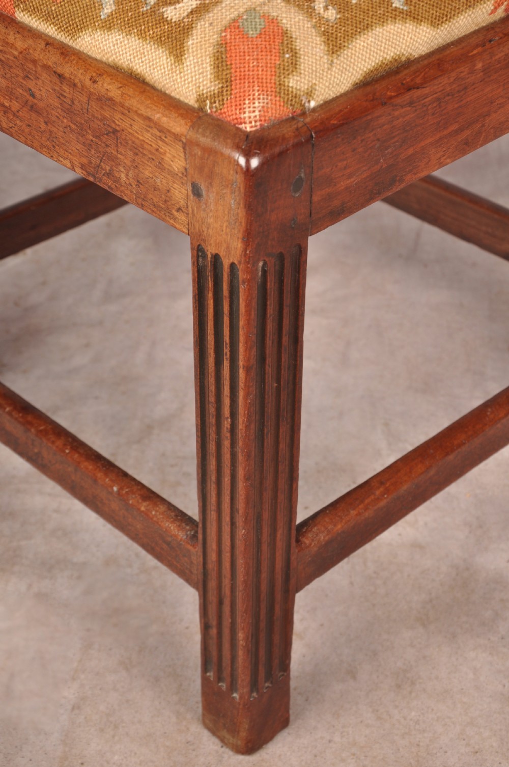 An 18th-century dark wood corner chair featuring a curved horseshoe backrest, dual pierced splats, turned uprights, fluted legs, and a patterned needlepoint drop-in seat. View VIII