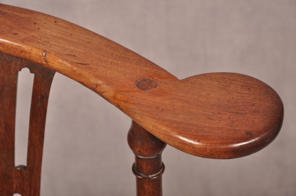 An 18th-century dark wood corner chair featuring a curved horseshoe backrest, dual pierced splats, turned uprights, fluted legs, and a patterned needlepoint drop-in seat. View X