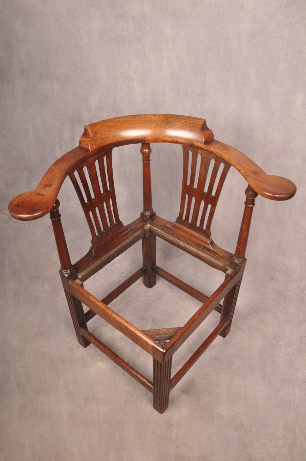 An 18th-century dark wood corner chair featuring a curved horseshoe backrest, dual pierced splats, turned uprights, fluted legs, and a patterned needlepoint drop-in seat. View XI