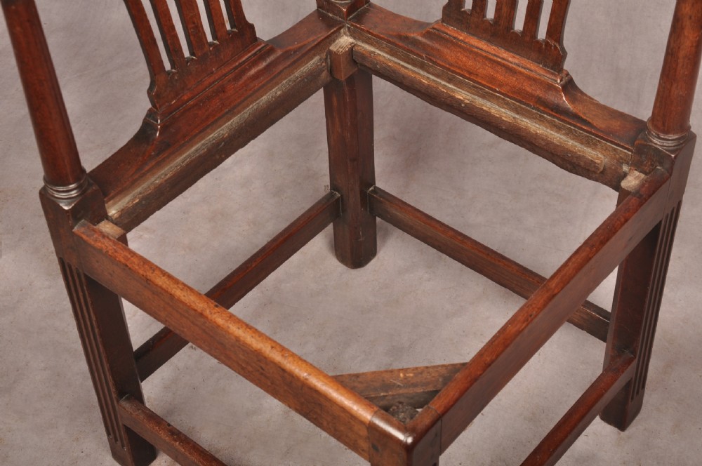 An 18th-century dark wood corner chair featuring a curved horseshoe backrest, dual pierced splats, turned uprights, fluted legs, and a patterned needlepoint drop-in seat. View XII